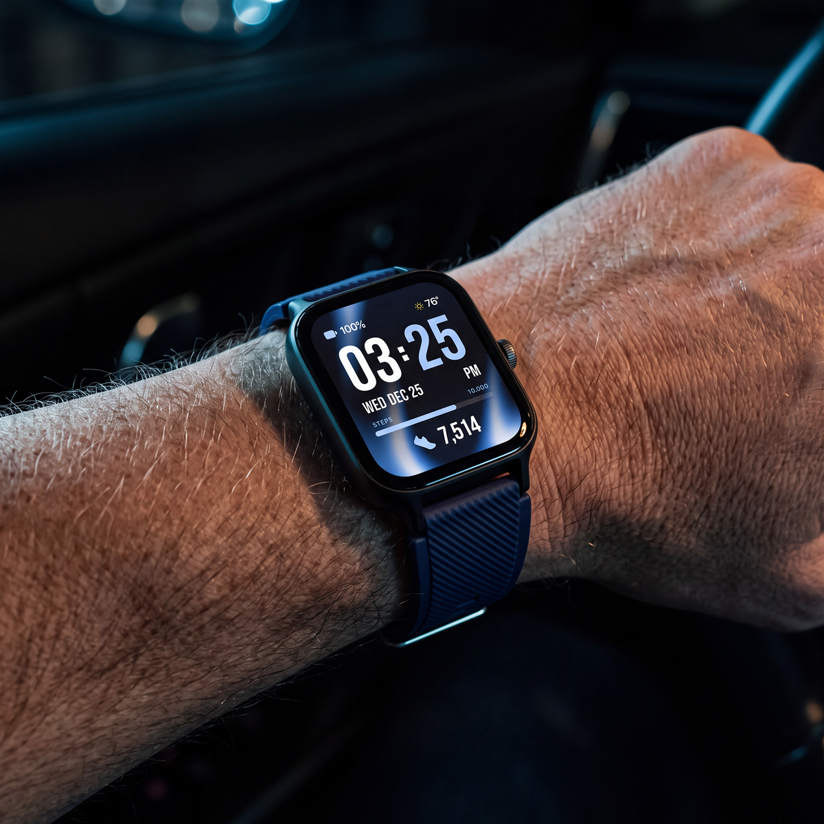 A close-up of a smartwatch with a navy blue band worn on a person's wrist inside a car.